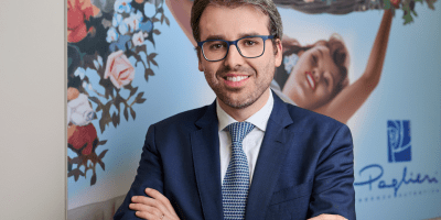 Matteo Tranfaglia, Marketing Director di Paglieri S.p.A., in un ritratto aziendale presso la sede del Gruppo, davanti a un pannello dedicato ai marchi storici dell'azienda.