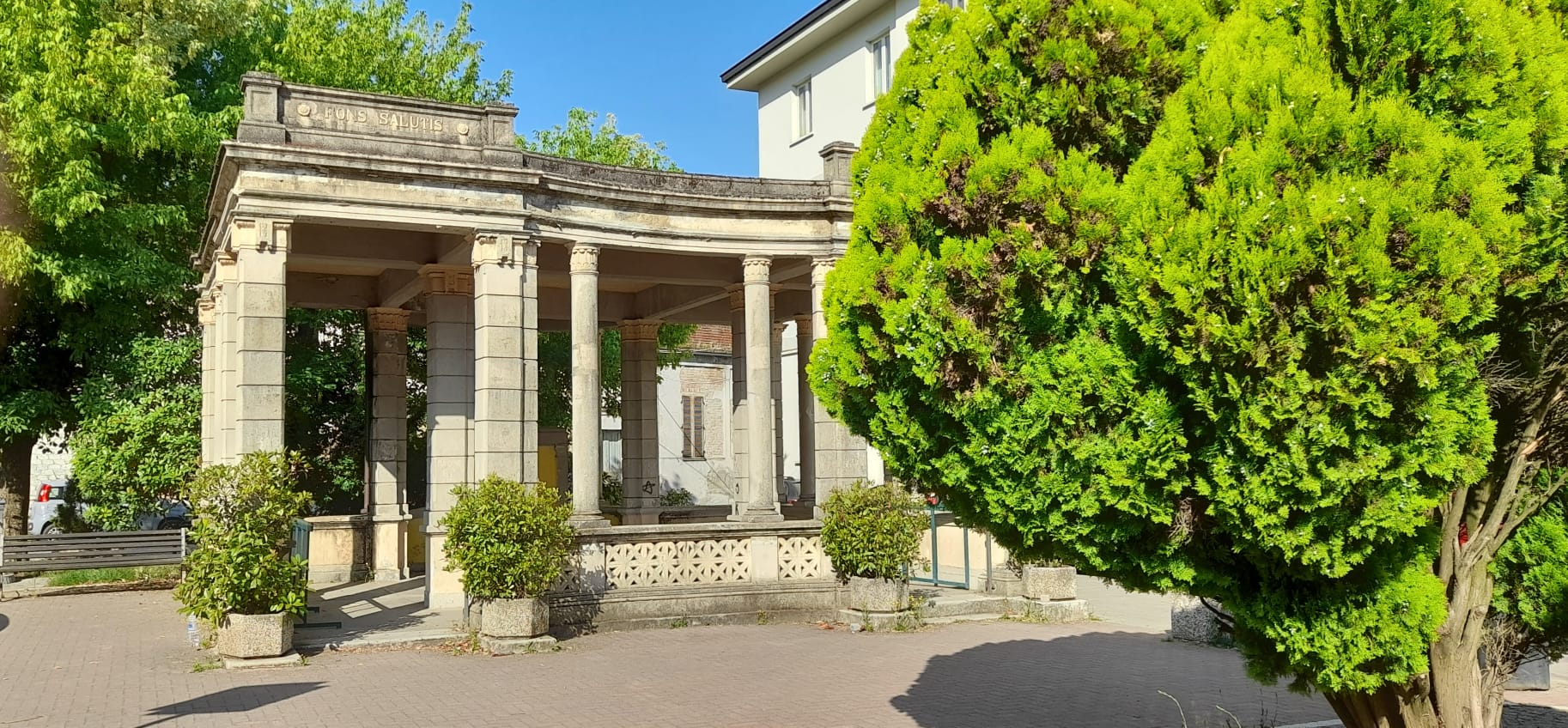 Storico padiglione monumentale nel centro di Valle San Bartolomeo ad Alessandria, circondato da alberi e aree verdi in una luminosa giornata estiva.