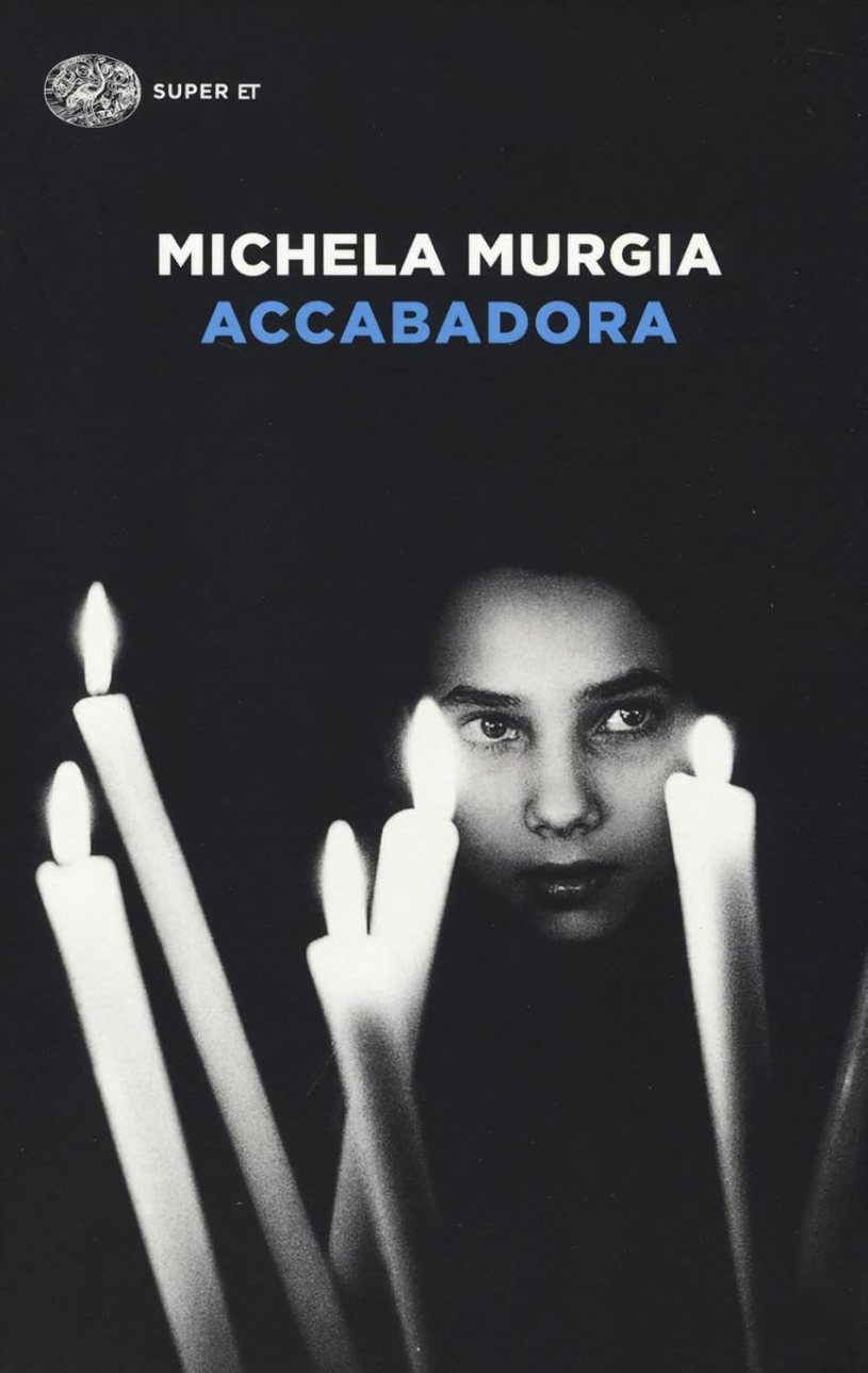 Copertina del romanzo Accabadora di Michela Murgia, con il volto di una giovane donna illuminato dalla luce di alcune candele, simbolo del mistero, della tradizione e del rapporto tra vita e morte nella Sardegna del Novecento.