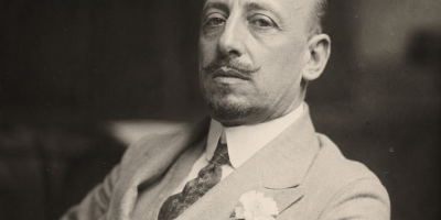 Ritratto fotografico realistico di Gabriele D'Annunzio in abito elegante d'inizio Novecento, con sguardo intenso e atmosfera storica, in stile fotografico ad alta risoluzione