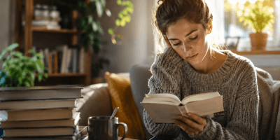 Persona che legge un libro in un ambiente luminoso e tranquillo.