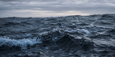 Mare in tempesta con onde scure e cielo nuvoloso, immagine simbolica ispirata alla poesia Allegria di naufragi di Giuseppe Ungaretti, metafora della lotta e della rinascita umana.