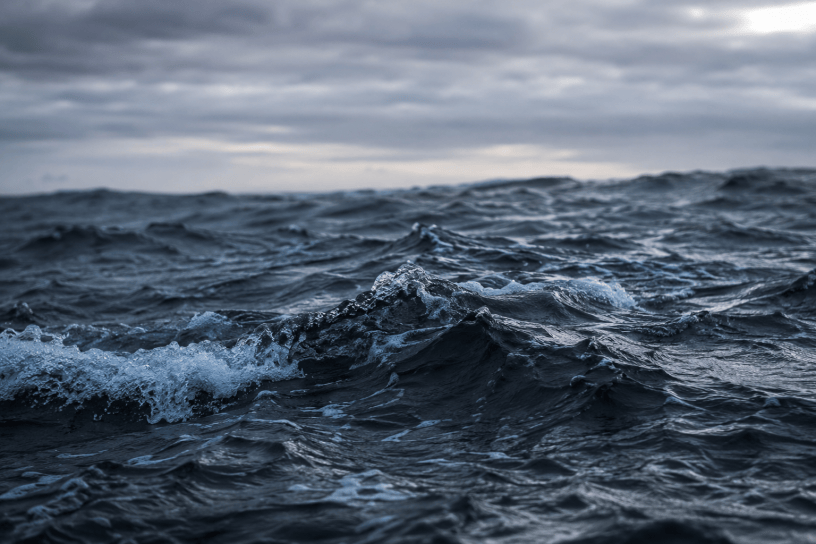 Mare in tempesta con onde scure e cielo nuvoloso, immagine simbolica ispirata alla poesia Allegria di naufragi di Giuseppe Ungaretti, metafora della lotta e della rinascita umana.