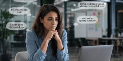 Professionista seduta davanti a un computer in un moderno ufficio mentre riflette con espressione preoccupata. Attorno a lei compaiono pensieri di dubbio e insicurezza legati alla sindrome dell'impostore, nonostante il successo professionale.