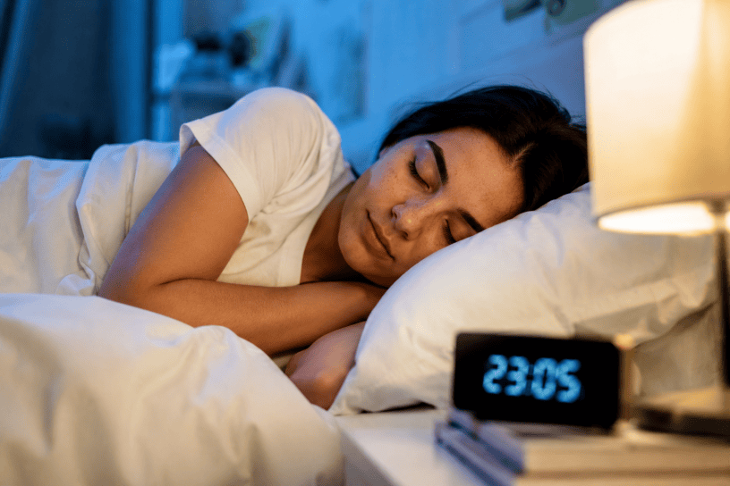 Donna che dorme serenamente nel proprio letto durante la notte, simbolo di riposo, benessere e qualità del sonno.