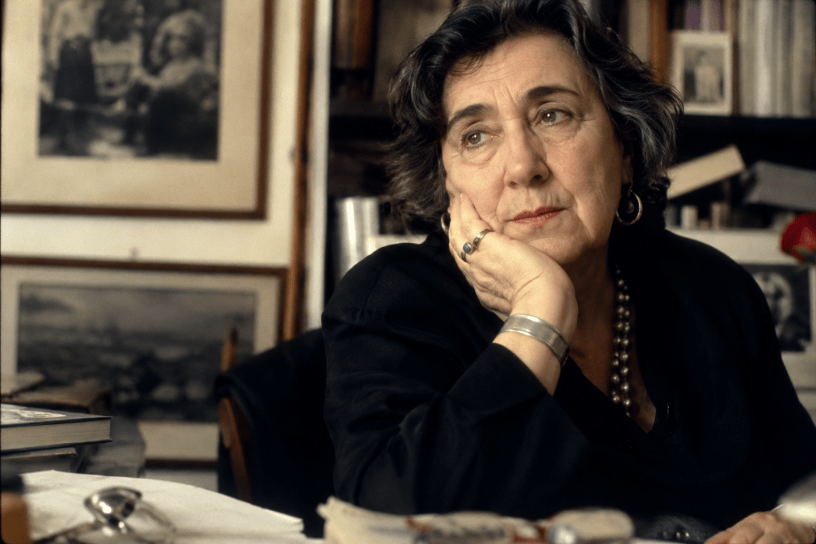 Ritratto fotografico ispirato ad Alda Merini, immersa in un ambiente raccolto tra libri, ricordi e luce soffusa, simbolo della libertà dei sogni e della forza della poesia.