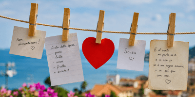 Mollette di legno fissate a un filo teso con appunti, messaggi e ricordi sospesi tra cielo, mare e luce del sole, simbolo del legame tra passato e presente.