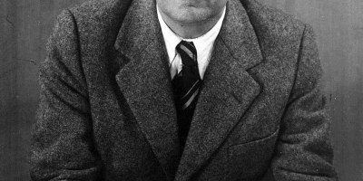 Ritratto in bianco e nero dello scrittore argentino Jorge Luis Borges seduto con gli occhiali tra le mani nel 1951.