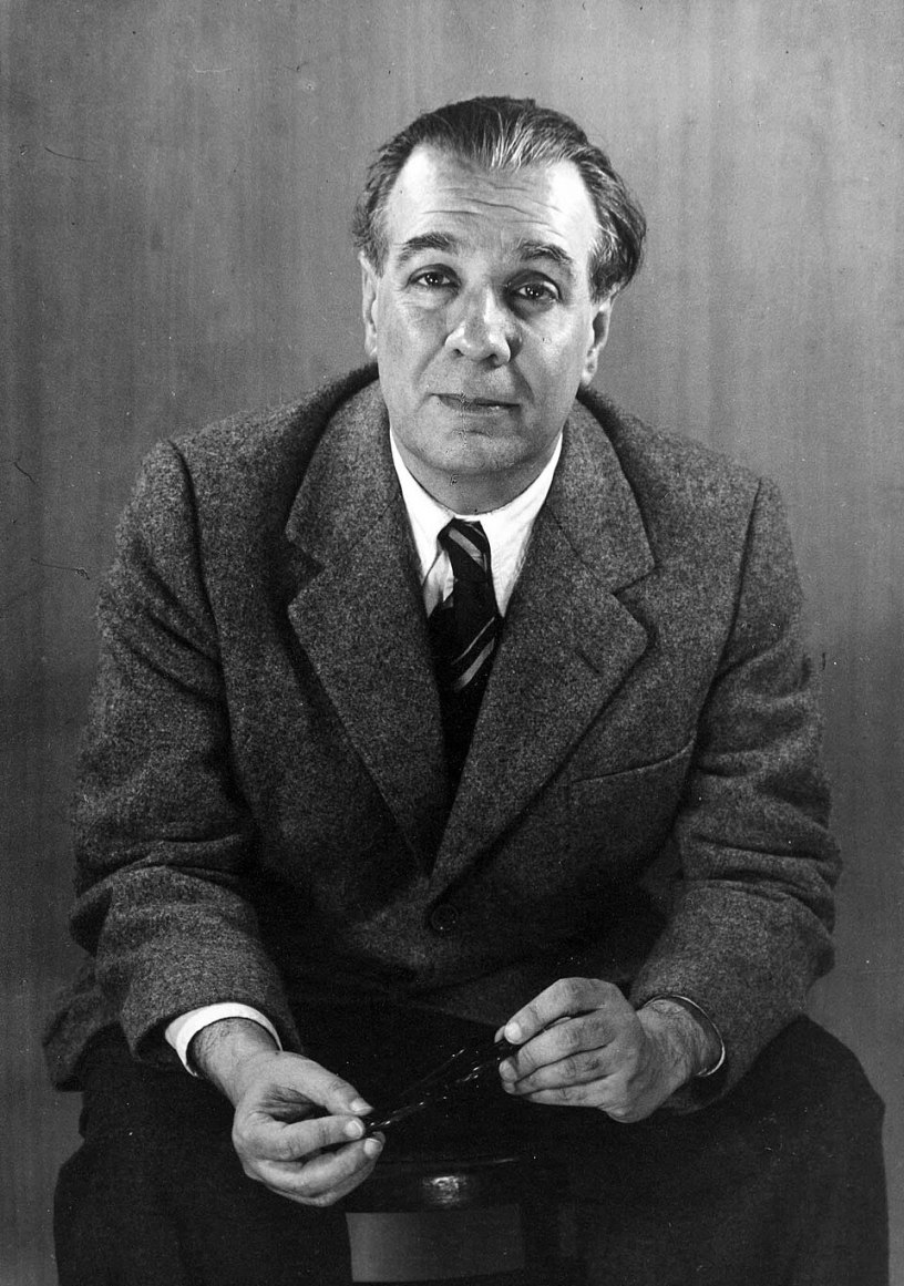 Ritratto in bianco e nero dello scrittore argentino Jorge Luis Borges seduto con gli occhiali tra le mani nel 1951.