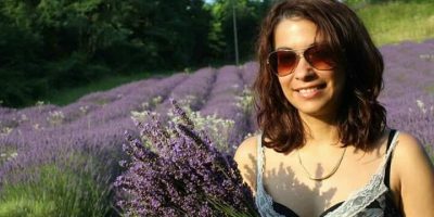 Yuleisy Cruz Lezcano in un campo di lavanda in fiore, simbolo dell'incontro tra culture, lingue e creatività letteraria, tema centrale del translinguismo poetico.