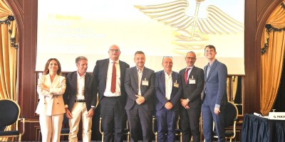 Partecipanti e relatori di MasterPharm 2026 riuniti sul palco durante la sessione inaugurale dell'evento dedicato all'innovazione e al futuro della sanità italiana a Baveno.