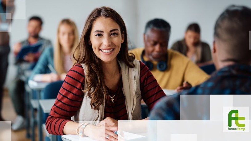 Partecipanti a un corso di formazione professionale in aula durante una lezione. In primo piano una giovane donna sorridente segue l’attività didattica, simbolo delle opportunità offerte dai voucher formativi per la crescita professionale