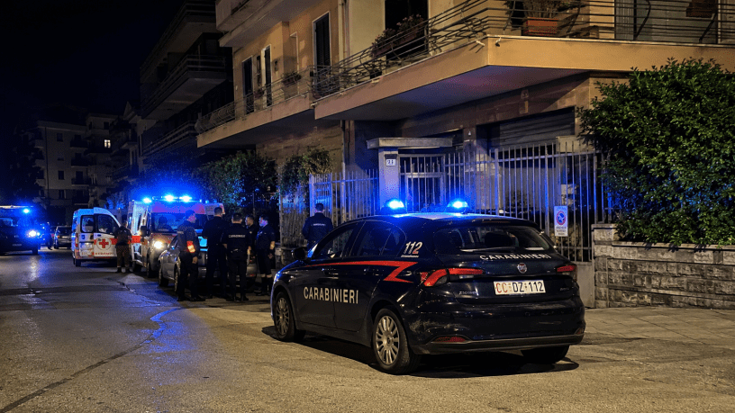 Carabinieri e mezzi di soccorso davanti a un condominio di Sanremo durante le indagini per l'omicidio di una donna trovata morta nella sua abitazione.