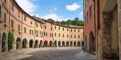 Veduta del Borgo Rotondo di Varese Ligure, con la piazza ellittica, i portici e le caratteristiche facciate colorate.