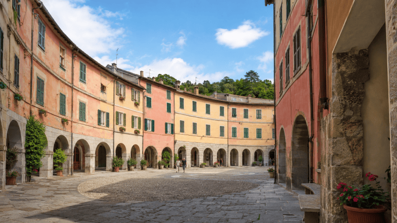 Veduta del Borgo Rotondo di Varese Ligure, con la piazza ellittica, i portici e le caratteristiche facciate colorate.
