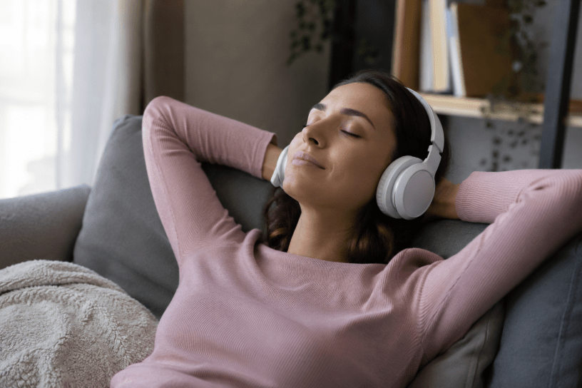 Una persona rilassata ascolta musica con cuffie in un ambiente domestico, simbolo degli effetti benefici della musica sul benessere psicofisico e sulla percezione del dolore.