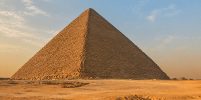 La Grande Piramide di Cheope sull’altopiano di Giza illuminata dalla luce dorata del tramonto.
