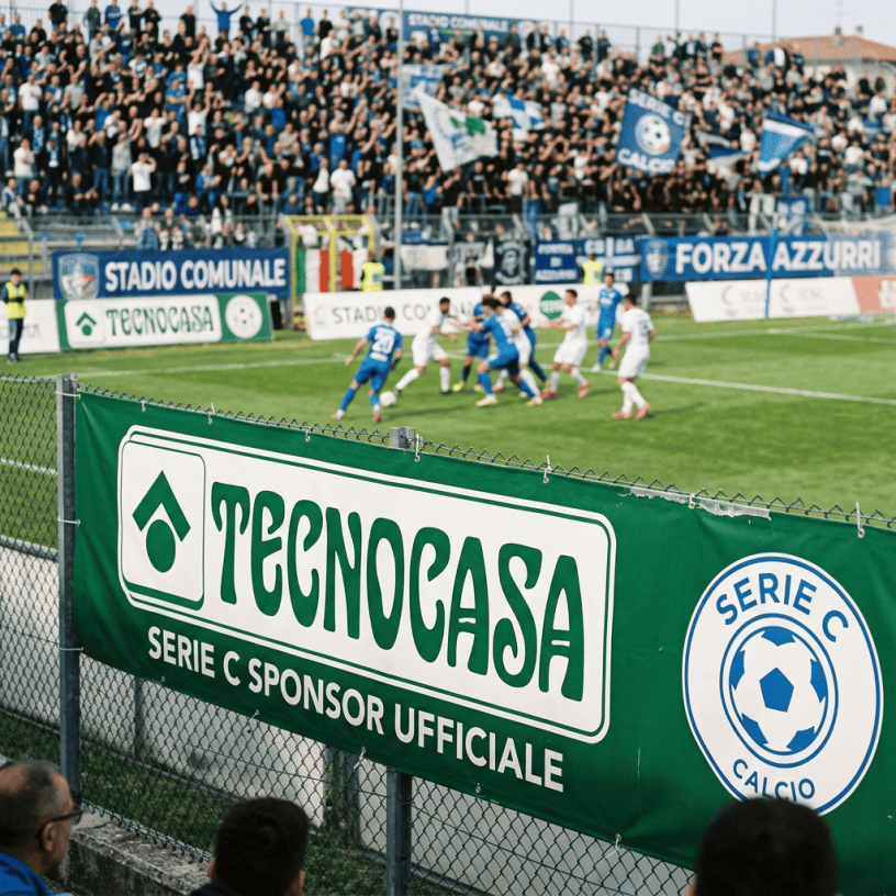Football players in blue and white jerseys contesting the ball near the goal during a Serie C match