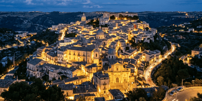 Historic town on a hill lit by streetlights during twilight
