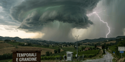 Storm clouds and lightning over farmland; sign reads “TEMPORALI E GRANDINE DAL 20 AGOSTO” and “DATI RILEVATI PRESSO LA STAZIONE METEO VAL TREBBIA.”