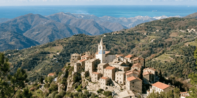 Stone hilltop village with church, terraced hills, and distant mountains