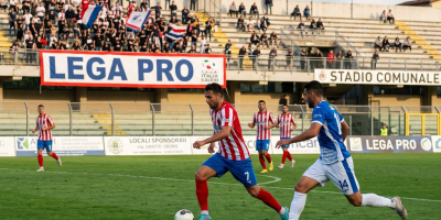 Football players competing on a field before a crowd at an Italian stadium