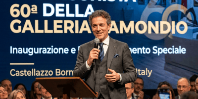 Davide Minetti speaking at a podium before a seated audience