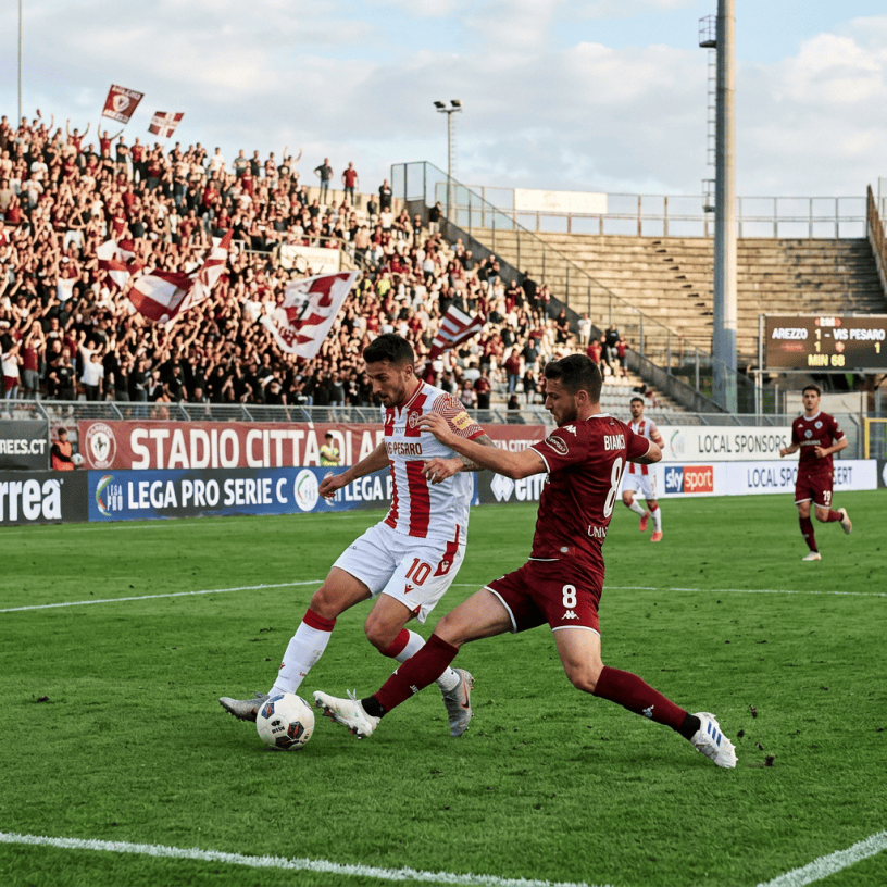 Two soccer players contest the ball during a Serie C match