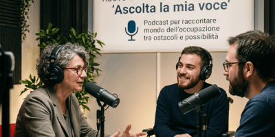 Three people recording a podcast beneath an Italian employment-themed sign