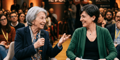 Two women seated onstage during a live discussion in Rome